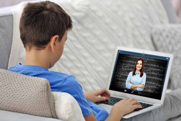 Boy with online tutor on screen