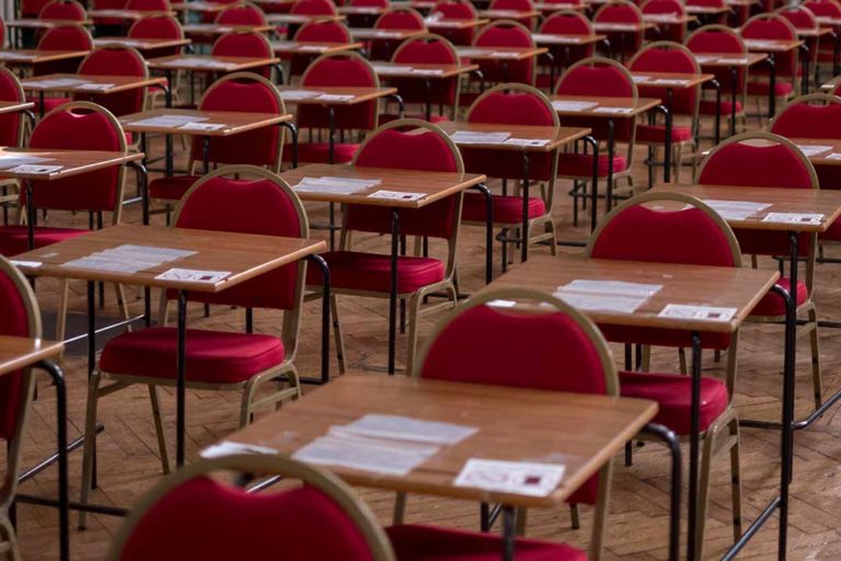 Empty exam hall with red chairs